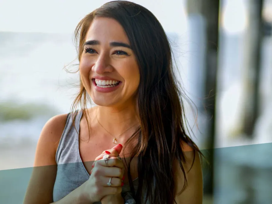 a woman smiling and holding a small bird