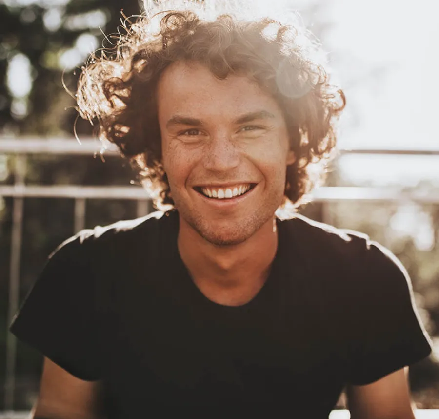 a person with curly hair smiling