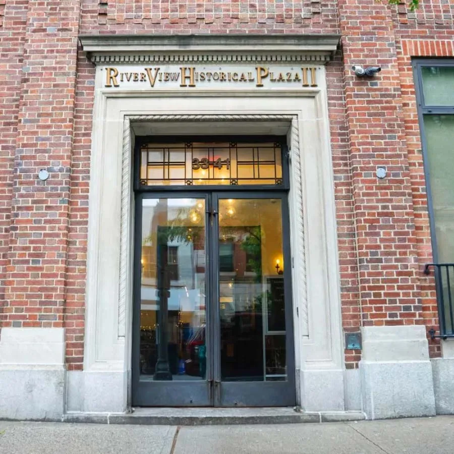 Entrance to River View Historical Plaza II with glass double doors in a brick building