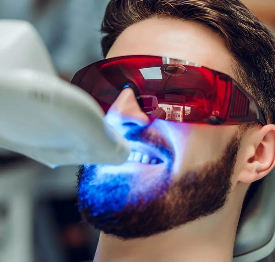 Two women smiling and reviewing information together on a tablet at a marble countertop with orchid flowers.