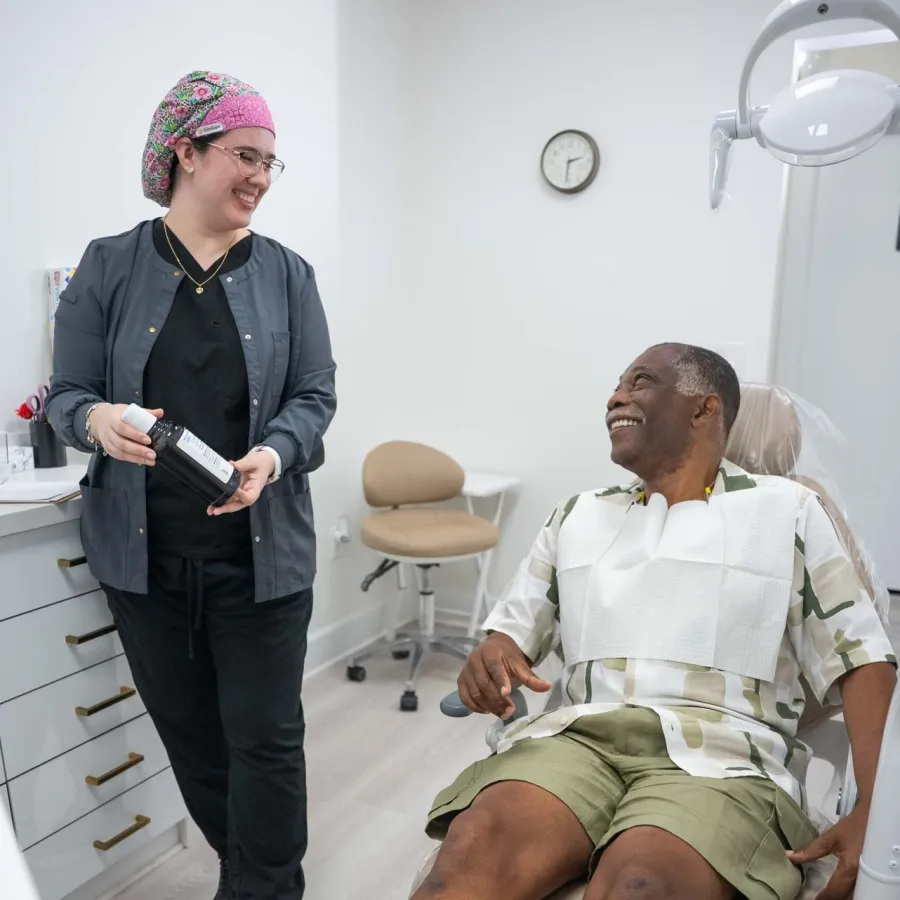 Two women smiling and reviewing information together on a tablet at a marble countertop with orchid flowers.