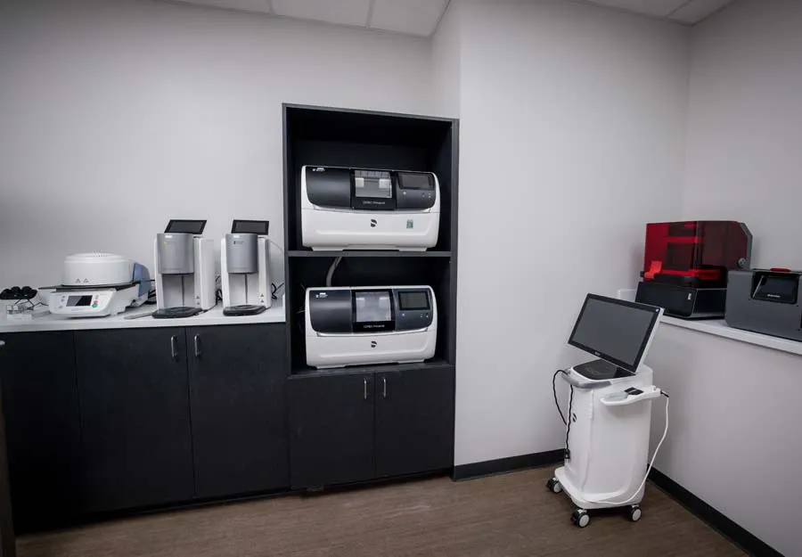 Modern laboratory room with advanced diagnostic machines and computer workstation on wheels
