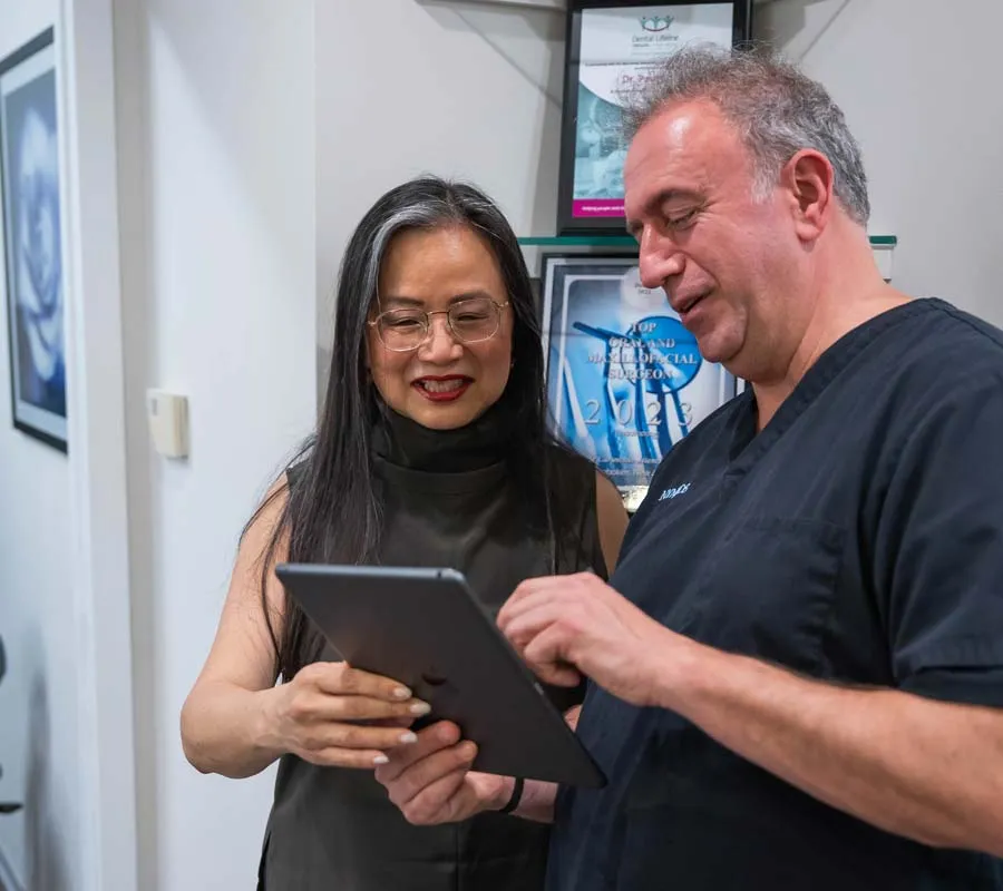 Doctor and patient discussing health information on a tablet in a medical office setting.