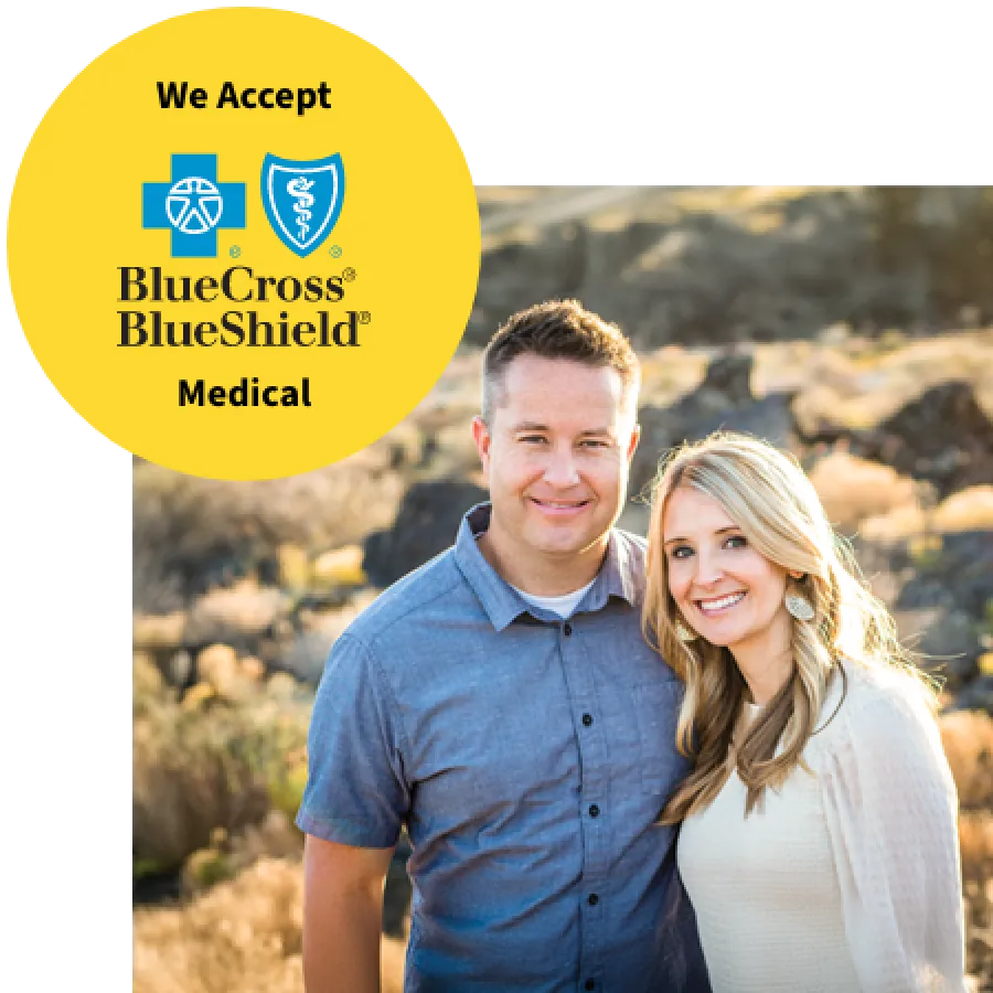 Smiling couple standing outdoors with Blue Cross Blue Shield Medical acceptance badge in upper left corner on yellow background