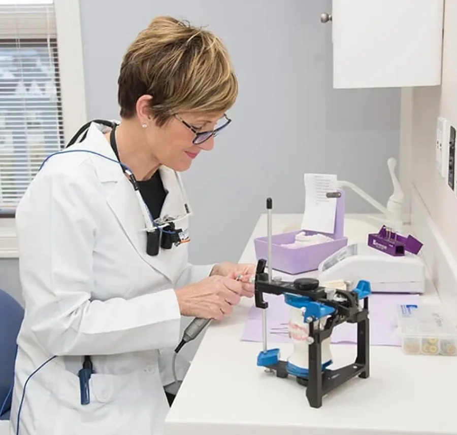 a person in a lab coat looking at a microscope