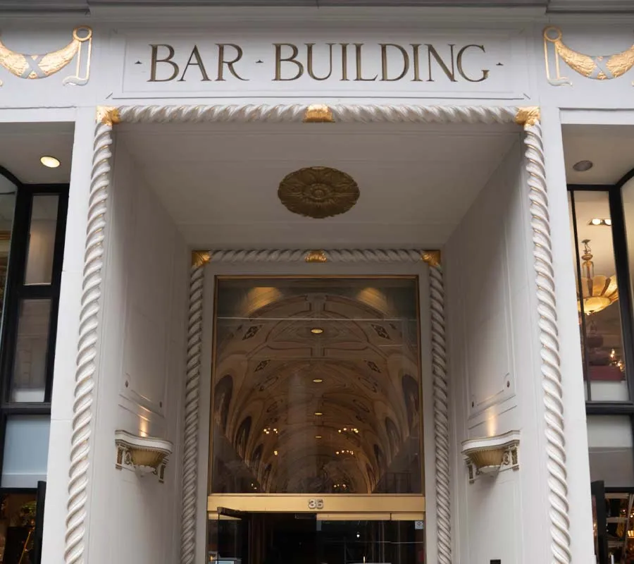 Entrance of the Bar Building with ornate white and gold decorative architectural details and glass doors
