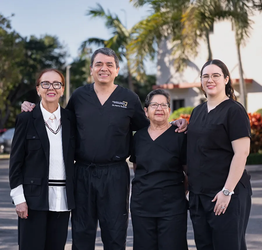 Exterior view of Shook Dental Care clinic with a large tooth logo on yellow building under clear sky