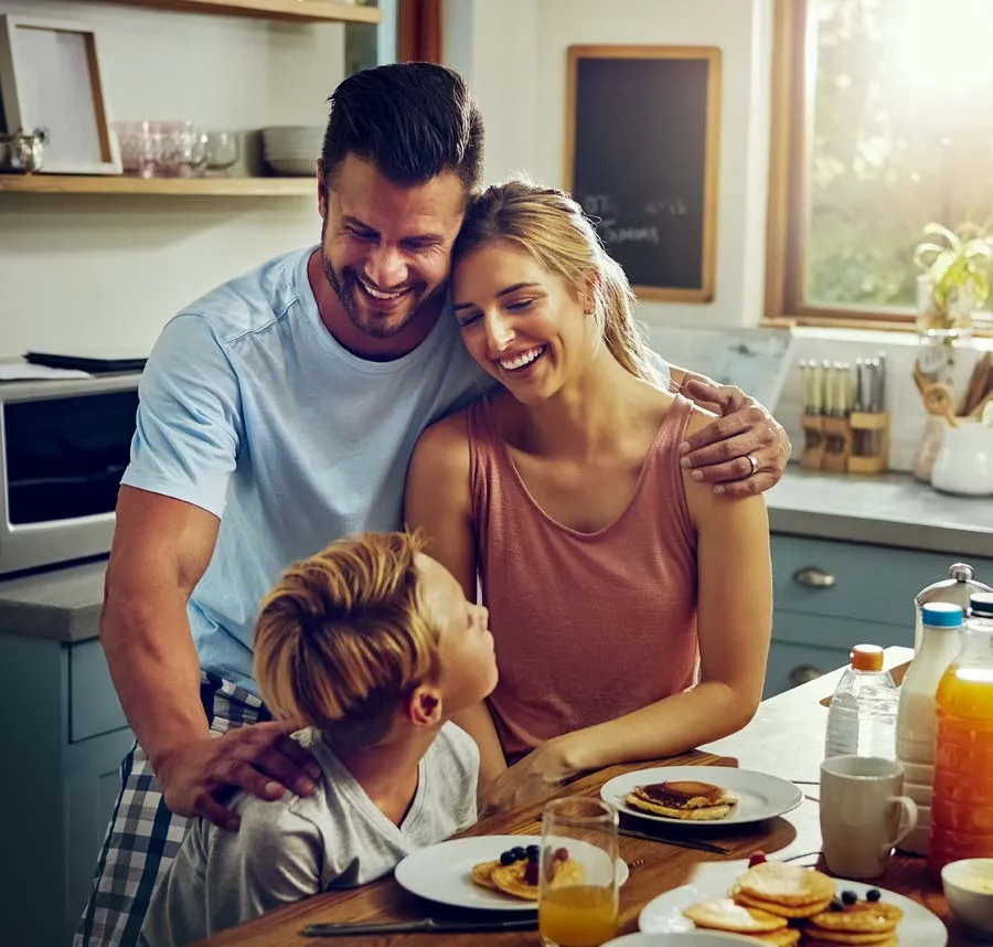 Family enjoying breakfast together in a bright kitchen, sharing smiles and moments of joy.