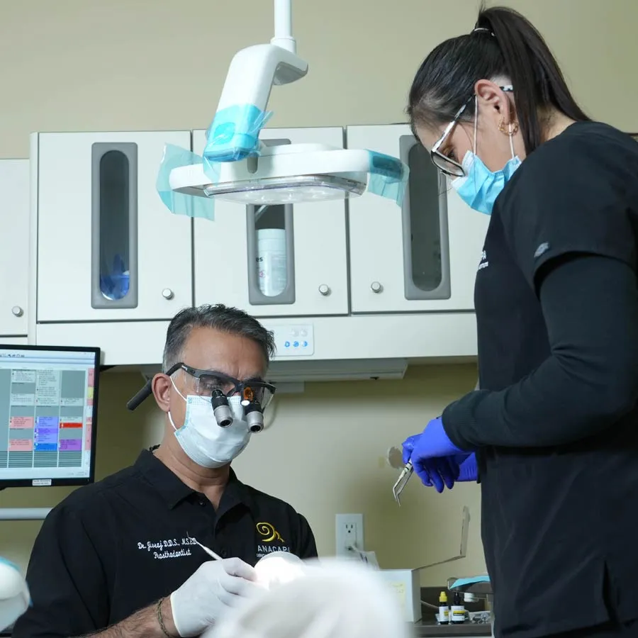 Dentist and assistant working in modern dental office with tools and equipment.