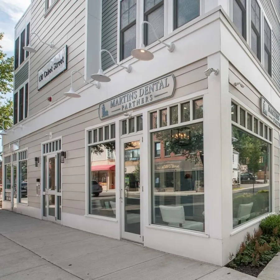 Exterior of Martins Dental Partners building with large glass windows on a city street corner.