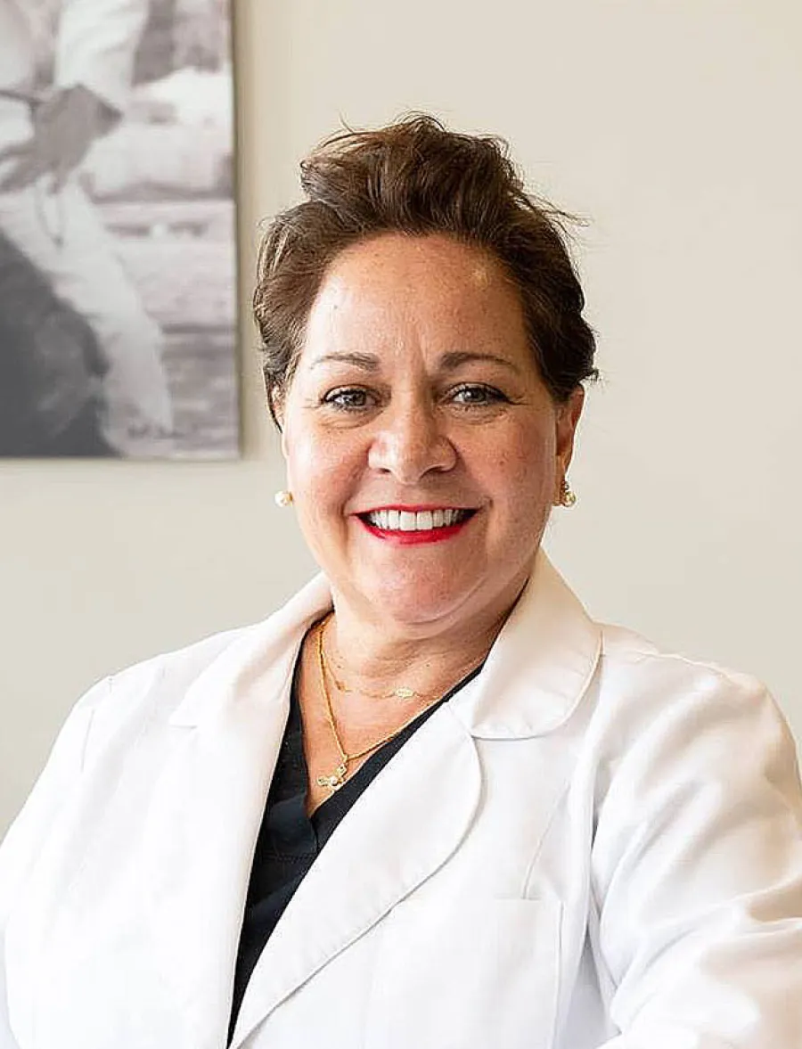Smiling female doctor in a white coat, showcasing professionalism and warmth in a healthcare setting.