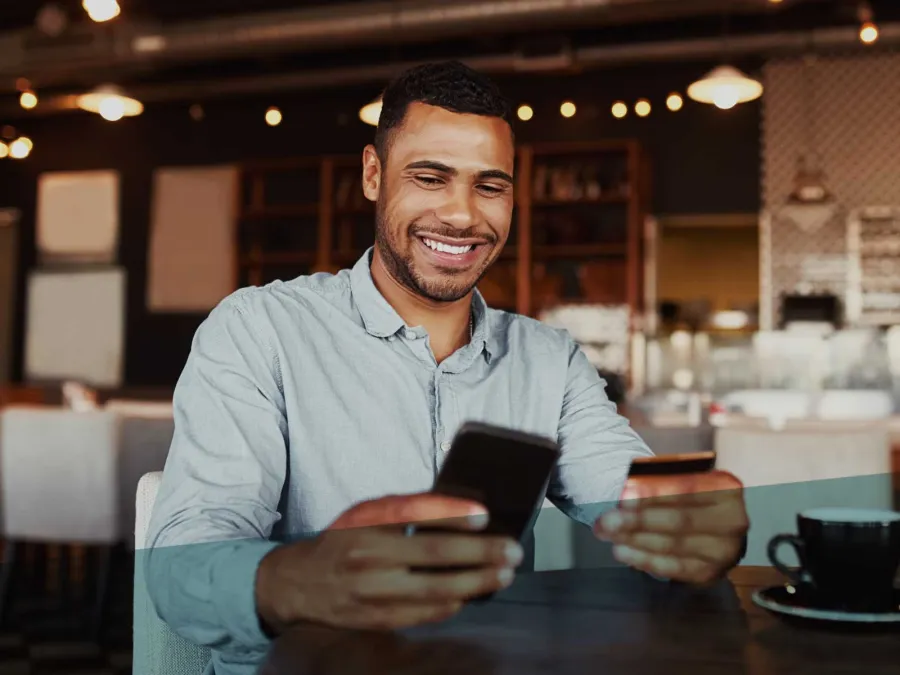 a man smiling and holding a phone