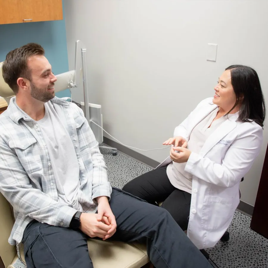 Patient and female doctor having a friendly consultation in a medical office with a computer in the background