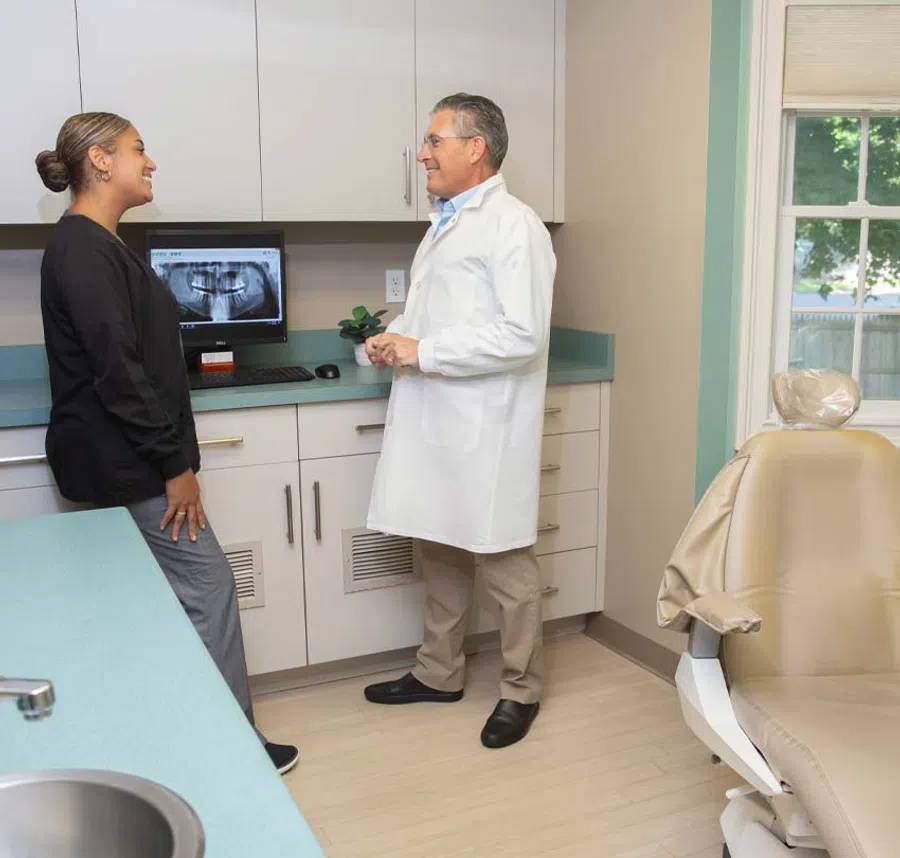 Dentist discussing dental x-ray results with a patient in a modern dental office consultation room.
