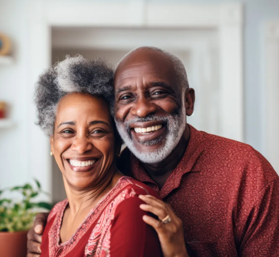 Happy older couple smiling and embracing each other indoors with warm natural light.