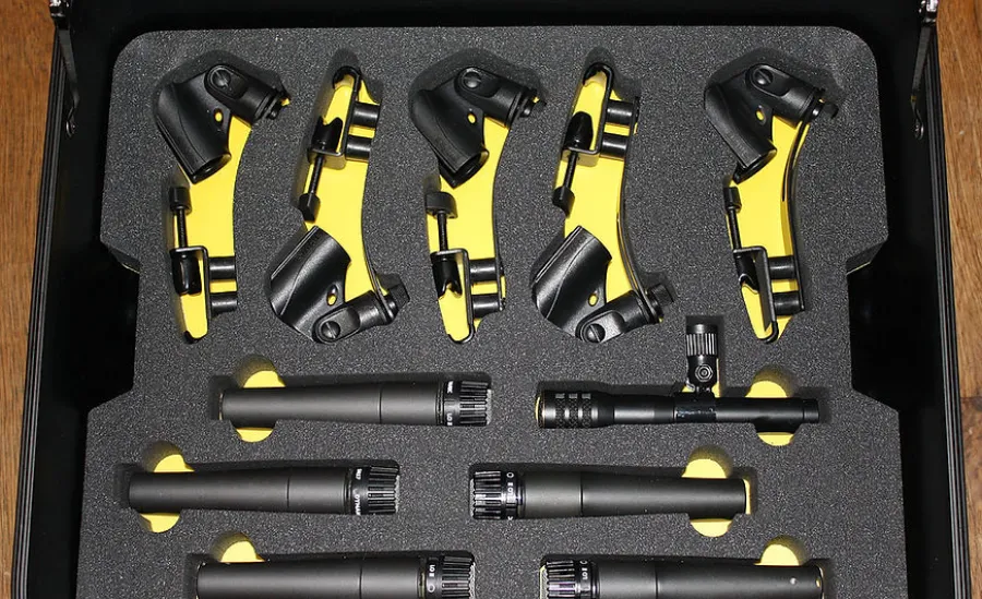 Set of black and yellow microphone clips and black microphones organized in a black foam case.