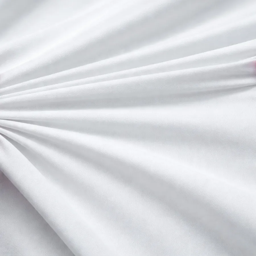 Soft white fabric with smooth folds and subtle texture arranged in a fan-like pattern