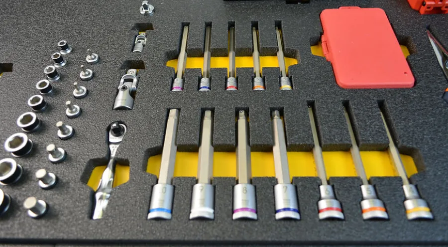 Mechanic's socket wrench set with various sized sockets and a ratchet handle neatly organized in foam case.