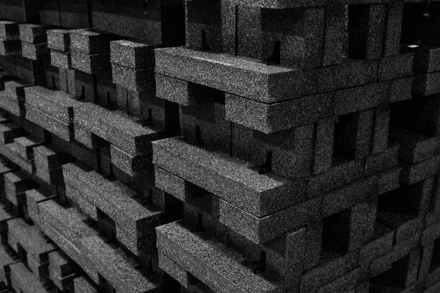 Close-up of stacked black foam blocks with textured surfaces creating a geometric pattern.