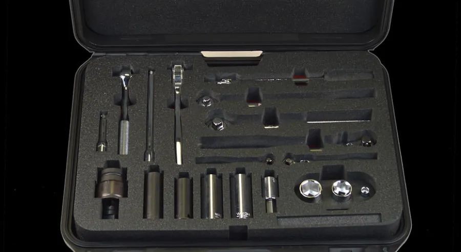 Open case with organized metal tools including sockets, ratchets, and extensions in foam inserts