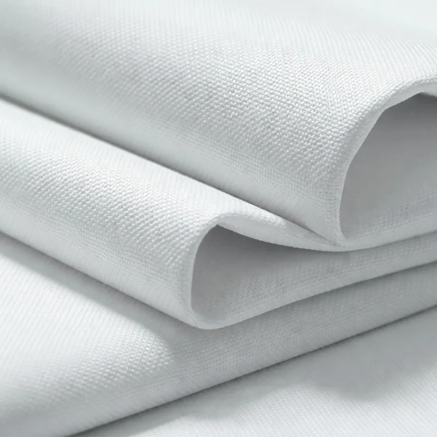 Close-up of folded white textured fabric showcasing detailed weave and soft material folds.