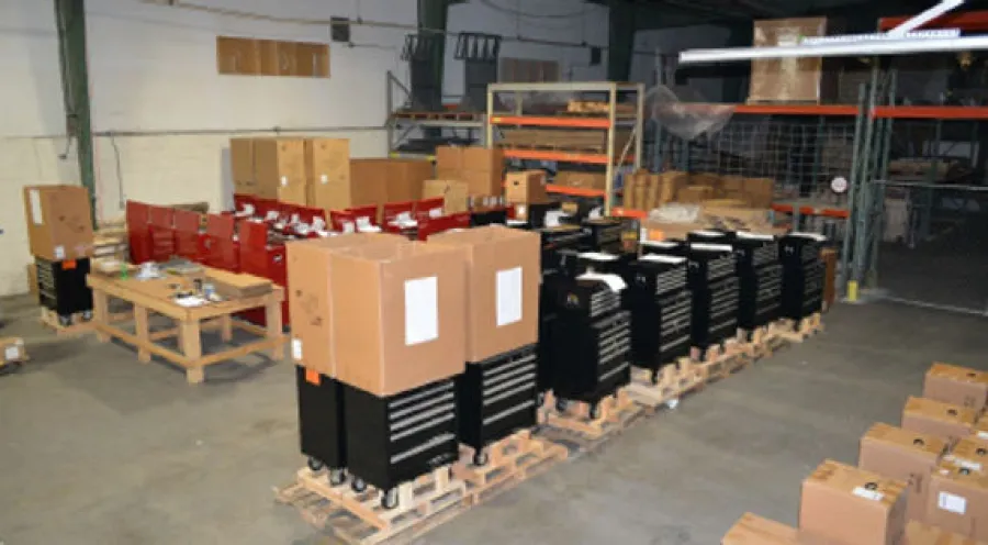 Warehouse storage with toolboxes on pallets and cardboard boxes organized in an industrial space