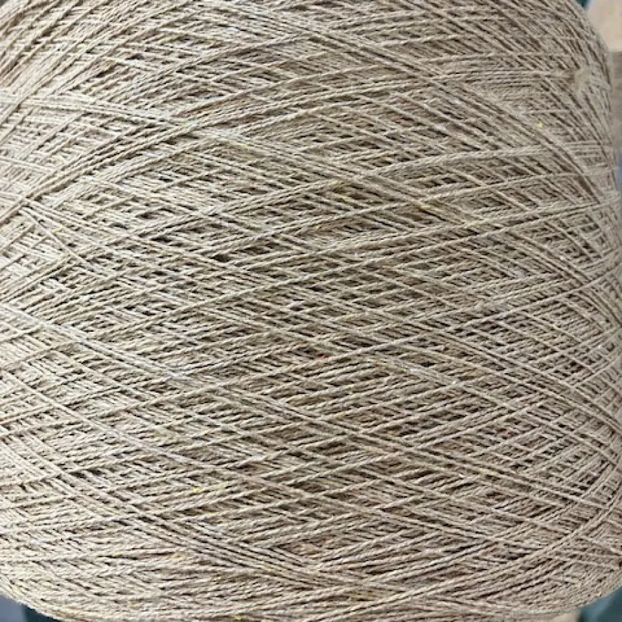 Close-up of natural beige cotton canvas fabric with visible weave texture rolled over flat surface