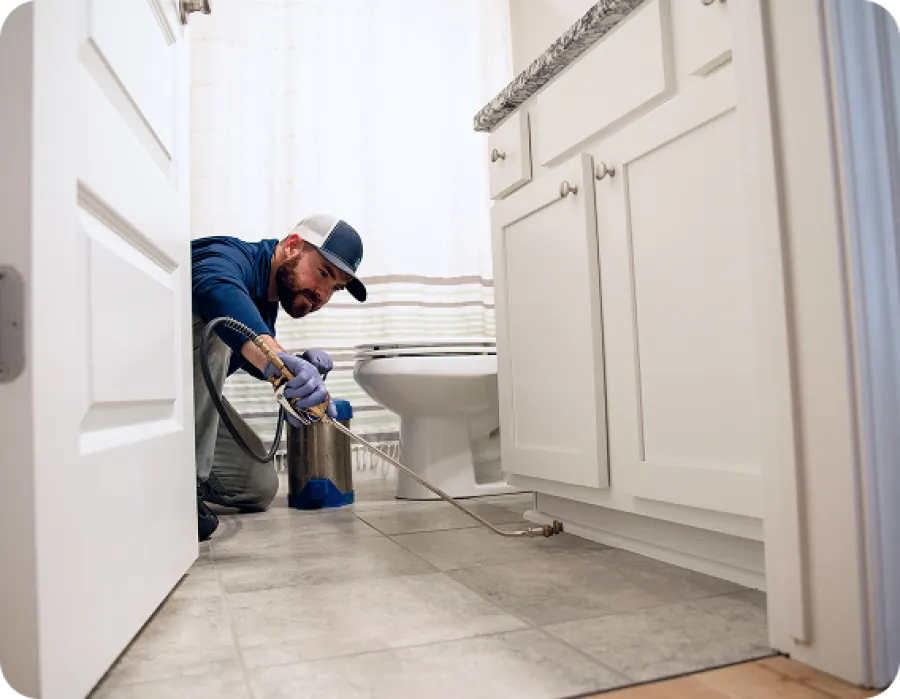 Professional plumber performing maintenance in a modern bathroom environment.