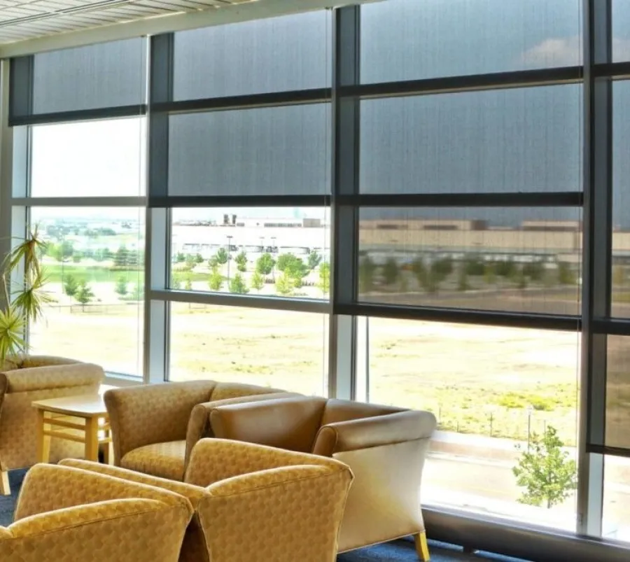 a room with a large window and a table with chairs and a plant