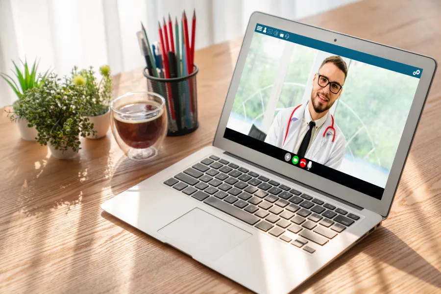 Laptop displaying a healthcare professional during a virtual consultation.