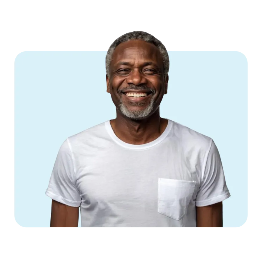 Smiling mature man with gray hair and beard wearing a white t-shirt against a light blue background