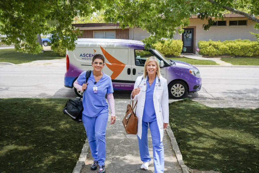 a couple of women posing for a picture in front of a car