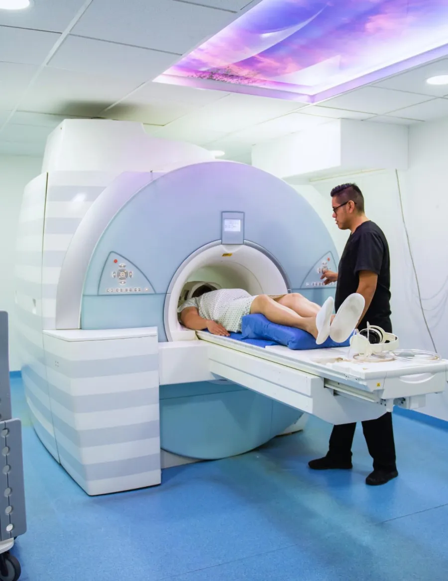 Modern hospital reception area with white walls, blue tiled section, elevator, and directional sign in Spanish