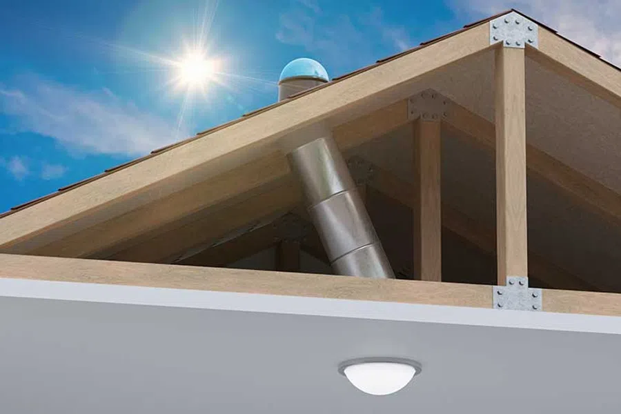 Close-up of wooden roof trusses and metal ductwork under bright sunlight with clear blue sky.