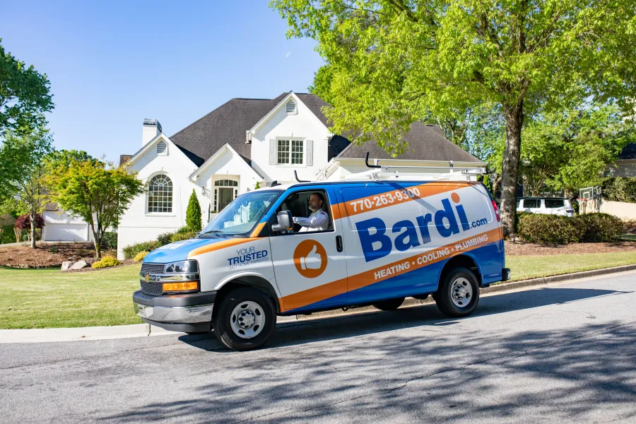 Bardi heating, cooling, and plumbing service van parked in front of a suburban house on a sunny day.