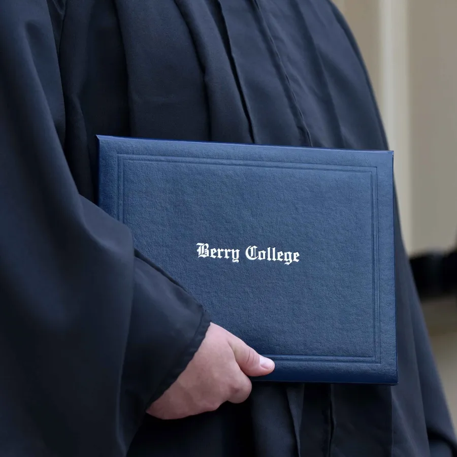 Graduate holding Berry College diploma