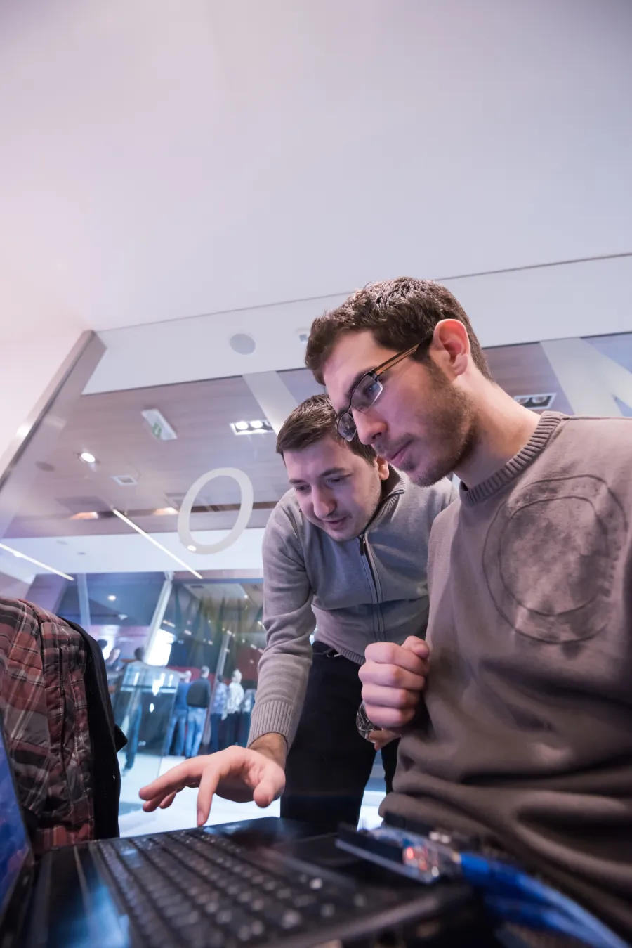 a couple of men looking at a computer screen