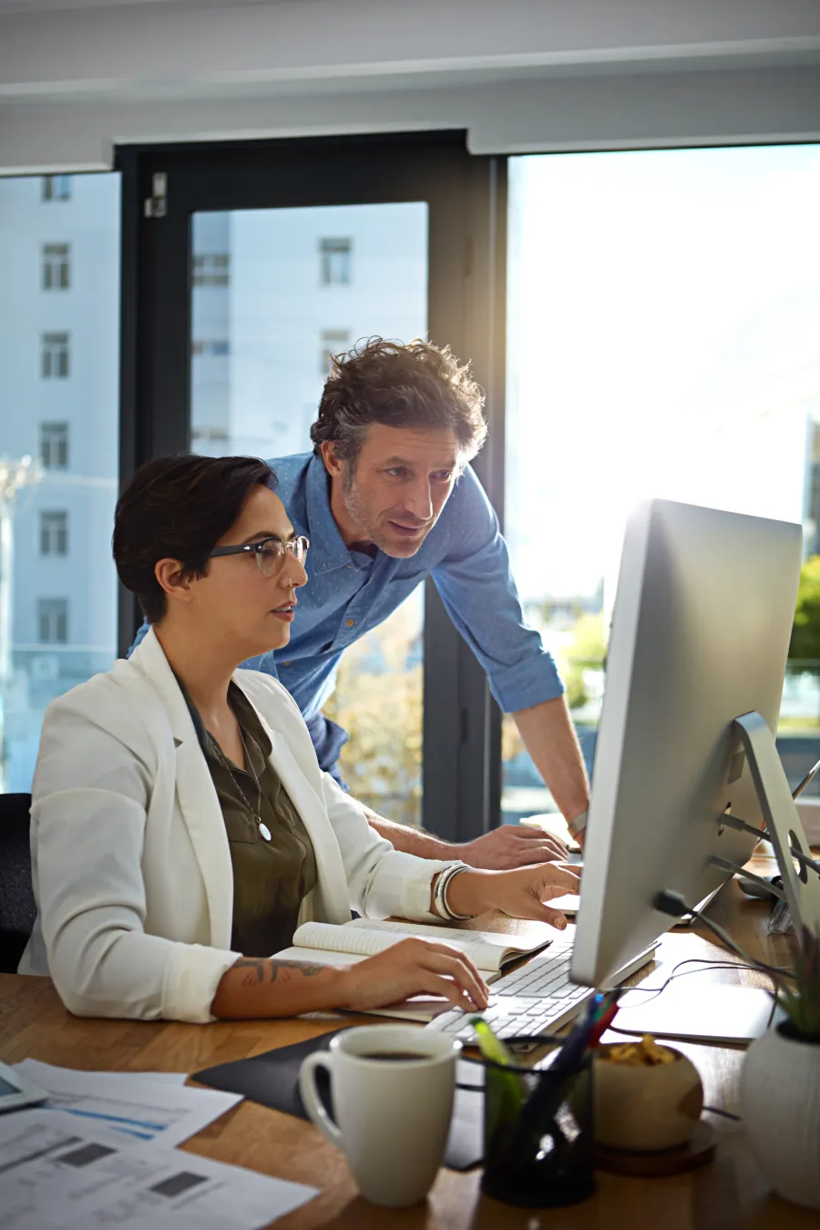 a man and a woman looking at a computer