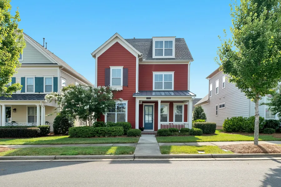 a red house with trees and bushes