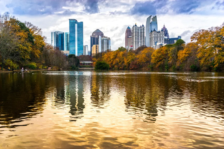 a body of water with trees and buildings in the background with Piedmont Park in the background