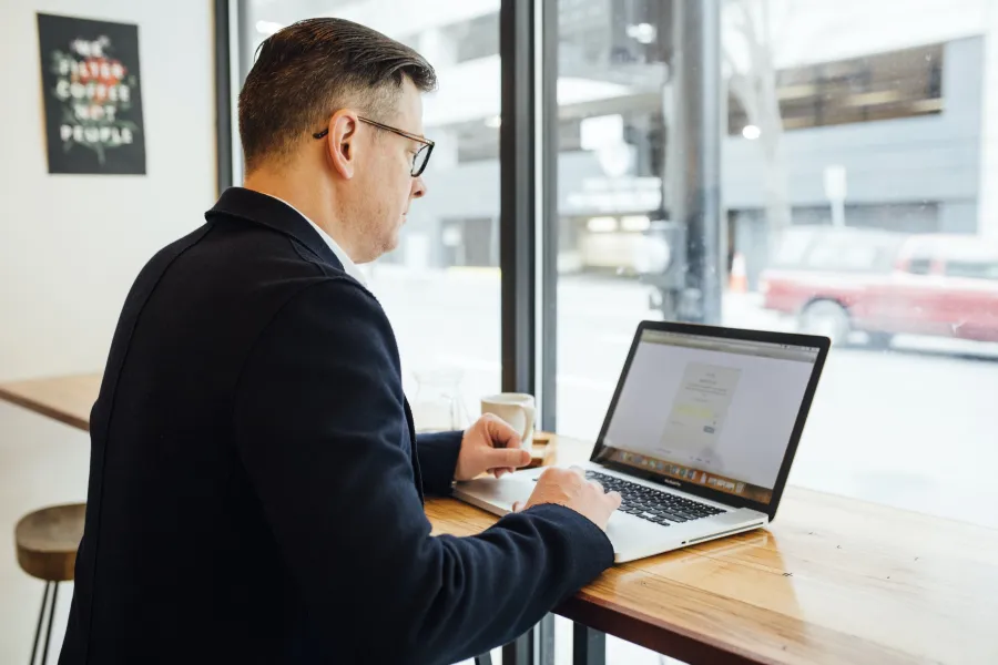 a person using a laptop computer sitting on top of a table