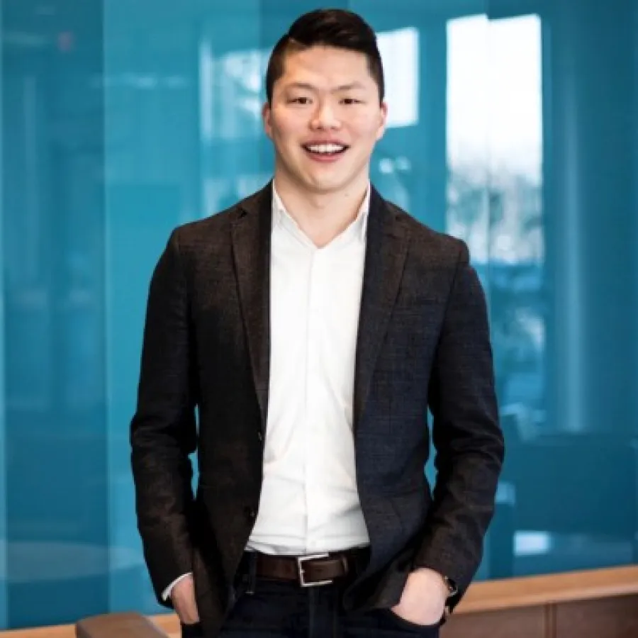 a man in a suit standing in front of a window