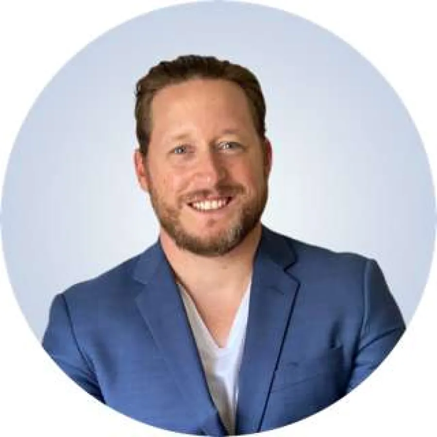 a man wearing a suit and tie smiling at the camera