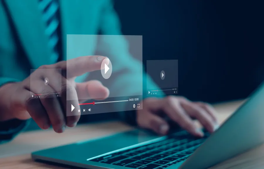Person interacting with virtual video player controls above a laptop keyboard in a digital workspace.