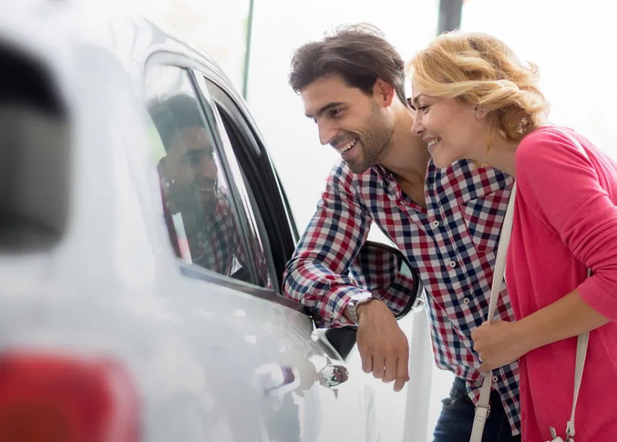 people standing next to a car