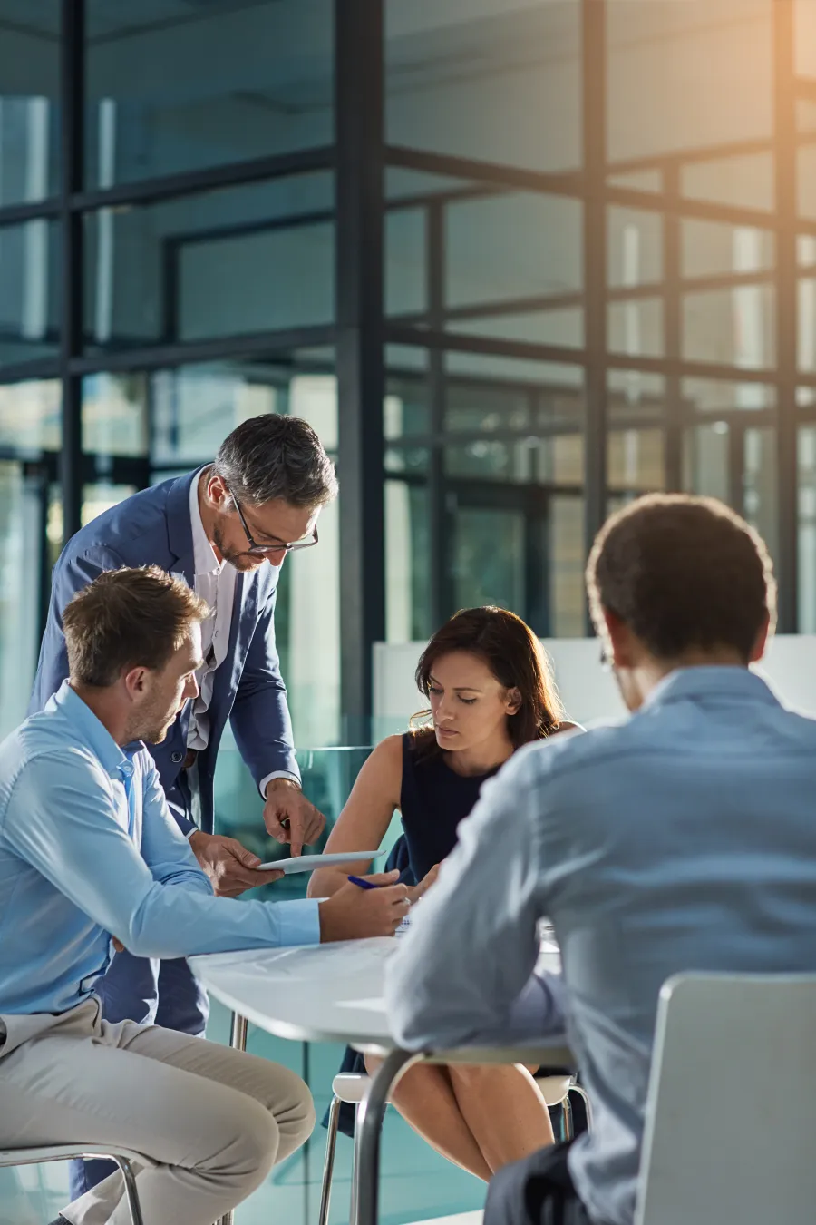a group of people sitting at a table looking at a phone