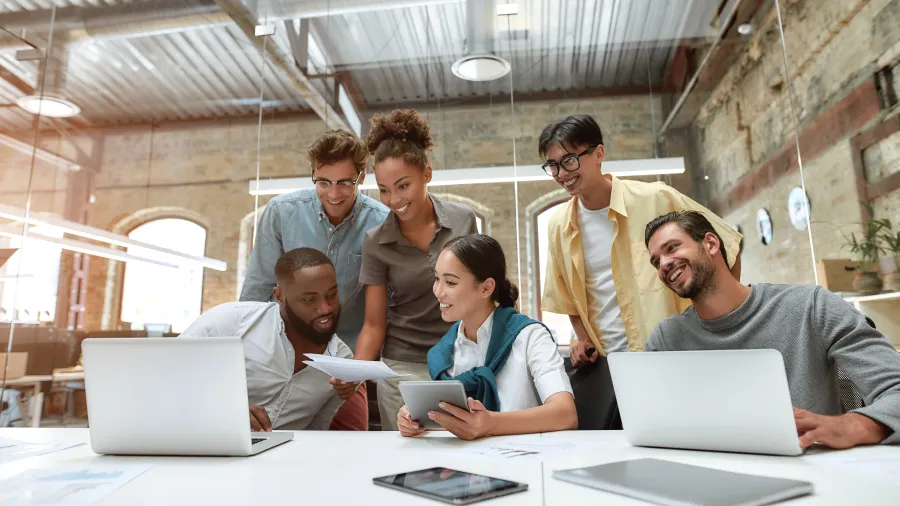 a group of people looking at a laptop