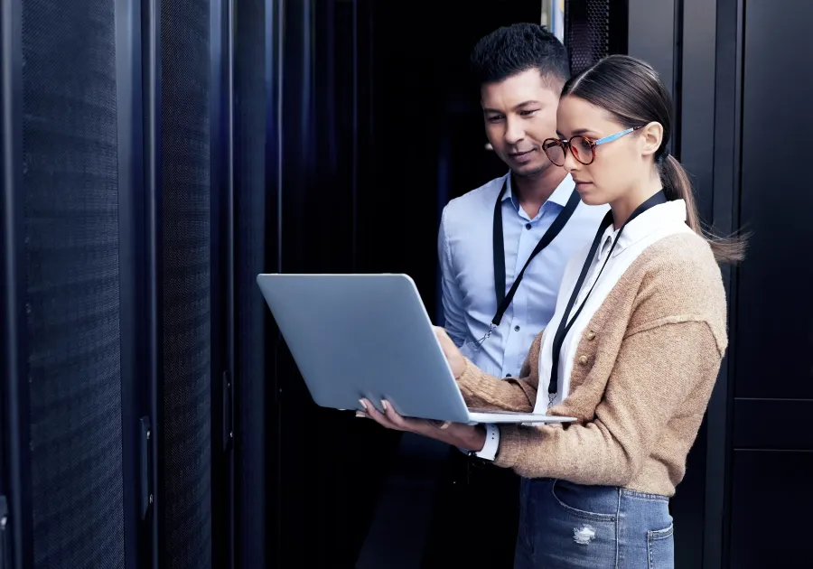 a man and a woman looking at a laptop