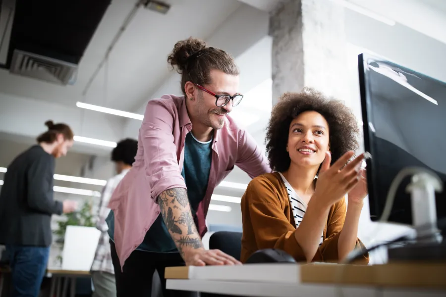 a man and a woman looking at a computer screen