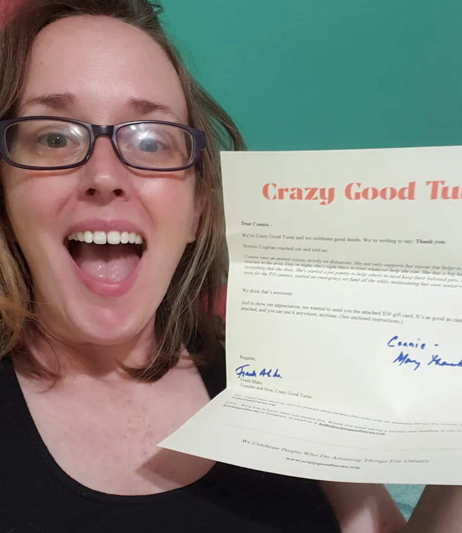 A woman holds the Thank You letter she received from Crazy Good Turns